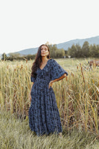 woman wearing bump friendly navy blue floral maxi dress with flowy sleeves and flowy skirt, perfect for bridal showers, weddings, church, baby showers, special events, easter and family photo shoots
